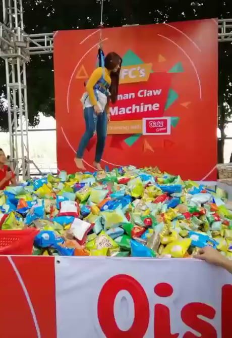 a woman standing in front of a giant pile of plastic bottles on stage at an event