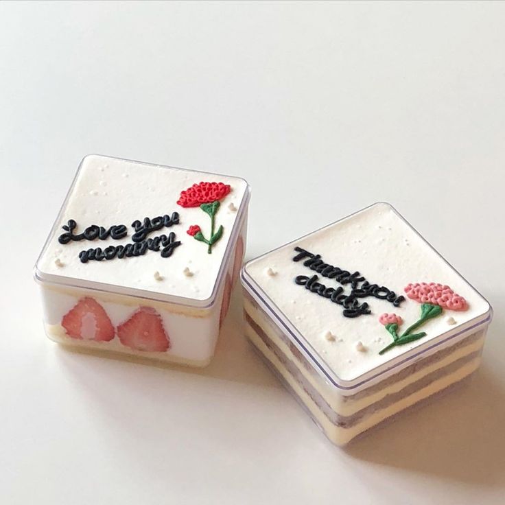 two small square cakes decorated with flowers and words