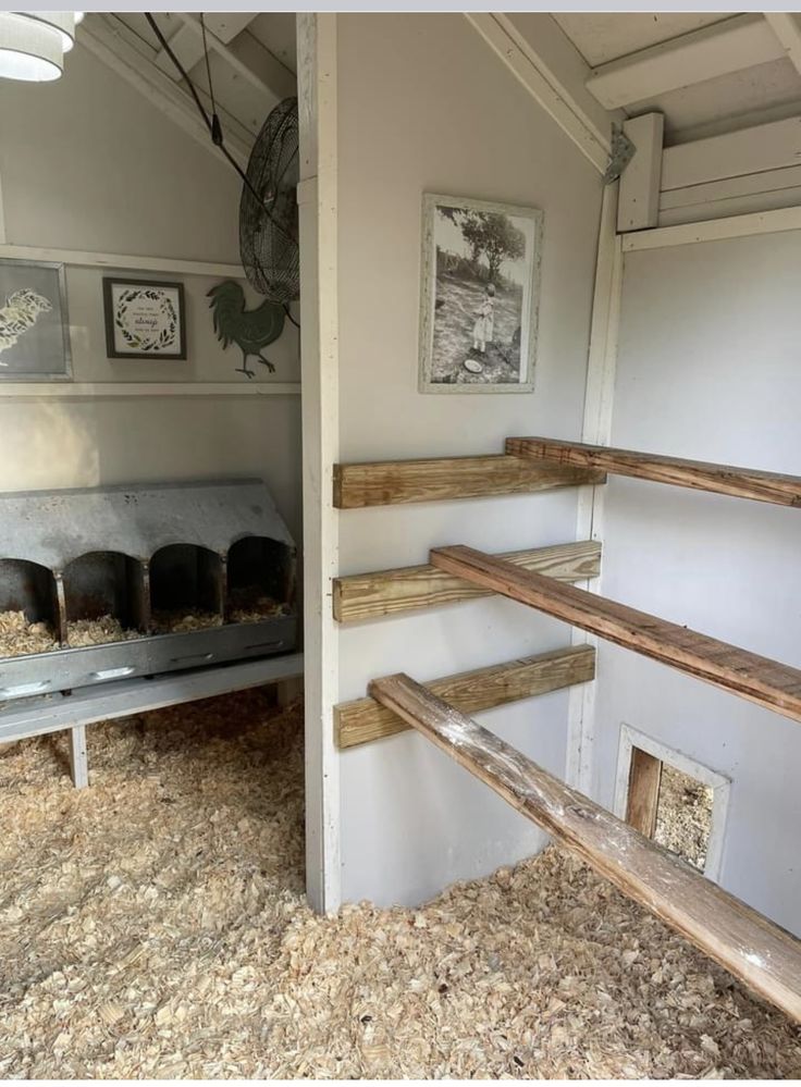 the inside of a horse barn with hay on the floor and wooden stairs leading up to it