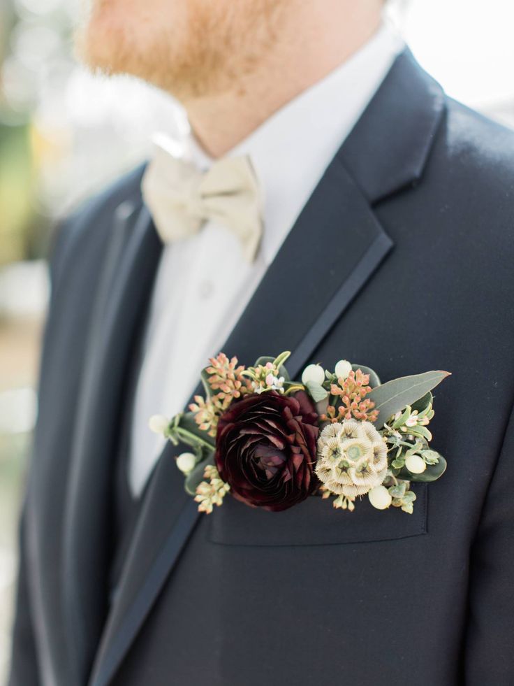 a man in a tuxedo wearing a boutonniere with flowers on it