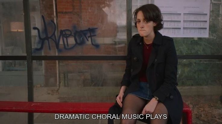 a woman sitting on top of a red bench in front of a wall with graffiti