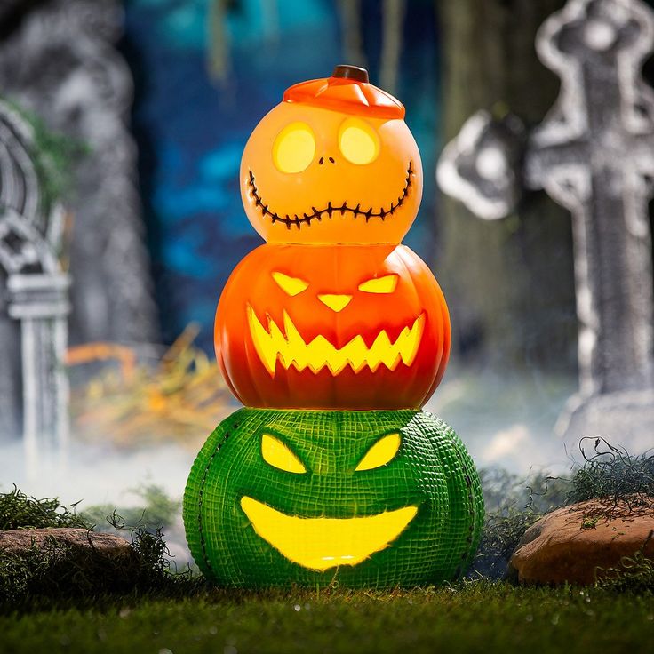 two pumpkins sitting on top of each other in front of tombstones and graves