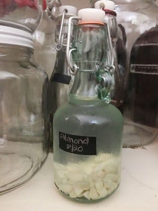 there is a glass bottle with something in it on the counter next to other jars