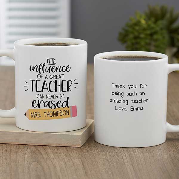 two white coffee mugs sitting on top of a wooden table next to each other