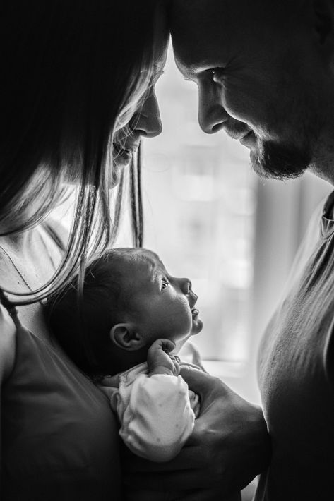 a man and woman holding a baby in their arms