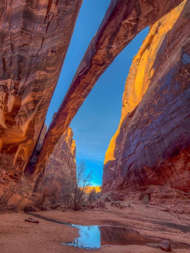 the sun is setting in between two large rock formations, with water running through them