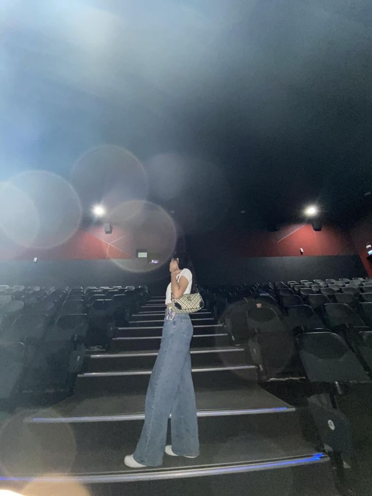 a woman standing in front of an empty theater