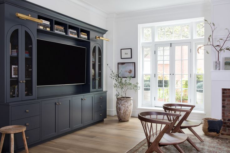 a living room filled with furniture and a flat screen tv on top of a wooden entertainment center