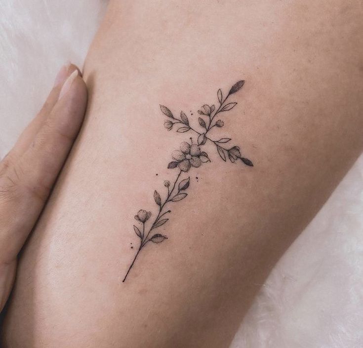 a woman's thigh with a flower tattoo on her left side ribcage