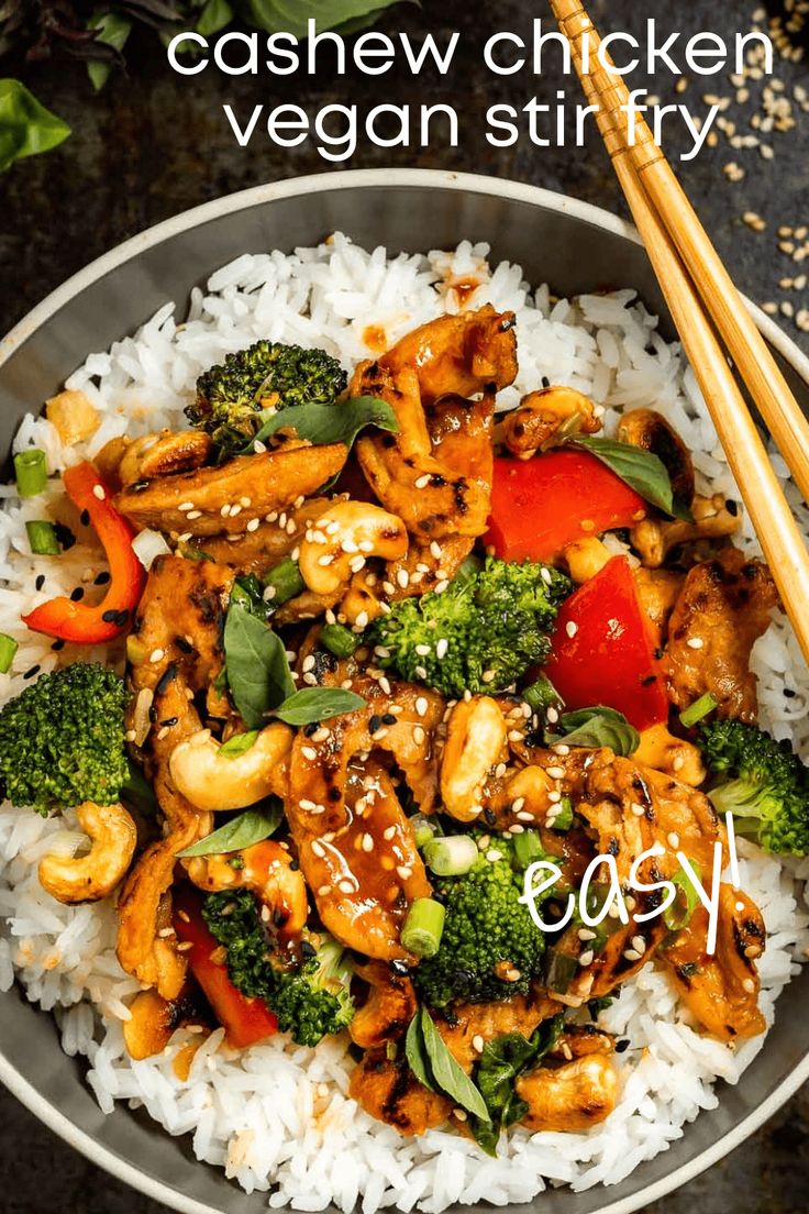 a bowl filled with chicken and broccoli on top of white rice next to chopsticks