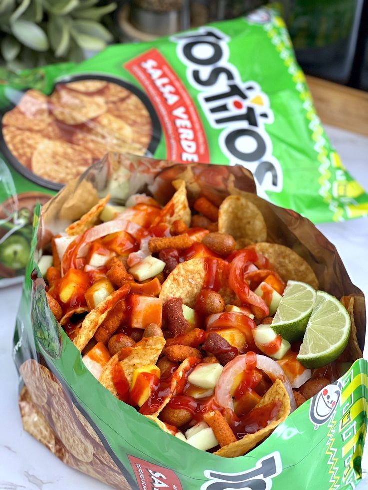 a bag of nachos sitting on top of a table next to some chips