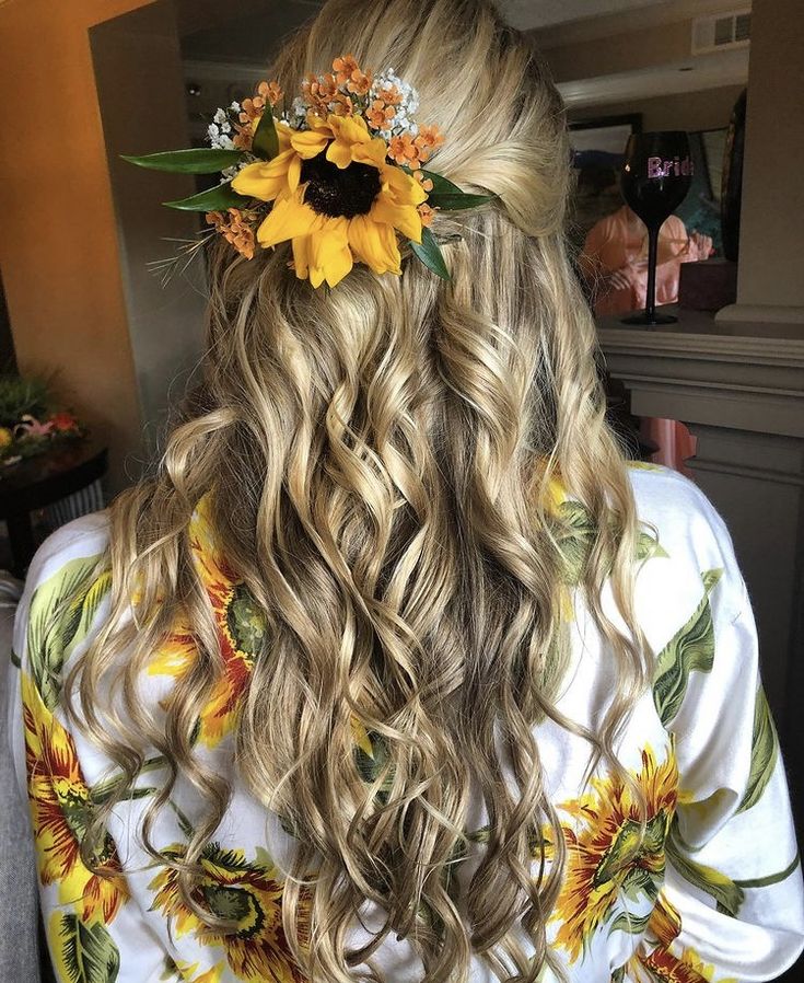 the back of a woman's head with sunflowers in her hair