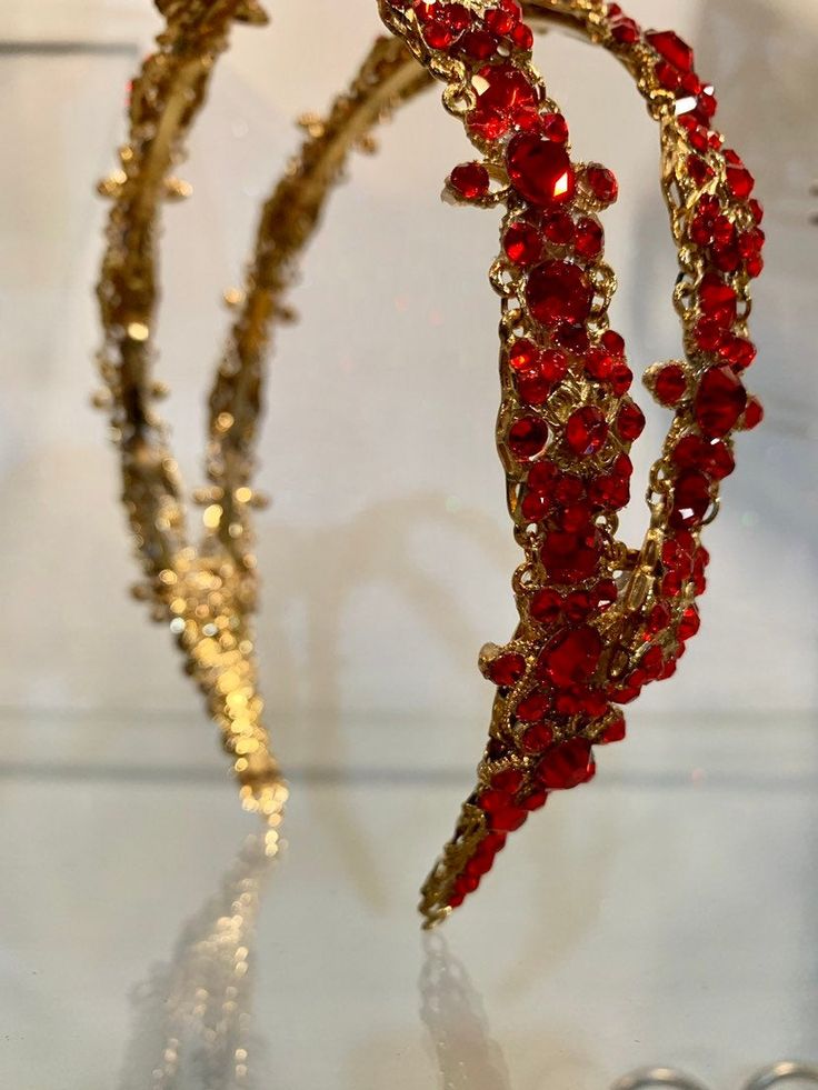 two red and gold bracelets sitting on top of a table