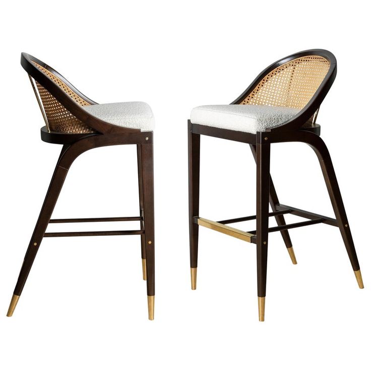 a pair of wooden chairs with white upholstered seat cushions and gold trimmings