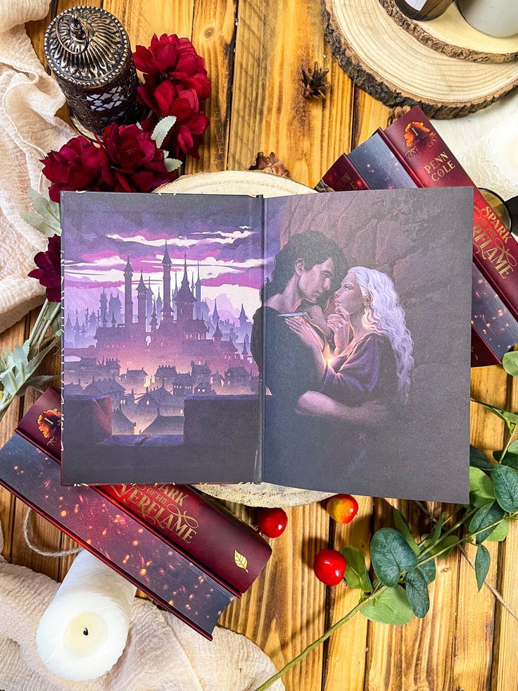 an open book on top of a wooden table next to candles and flowers with red roses