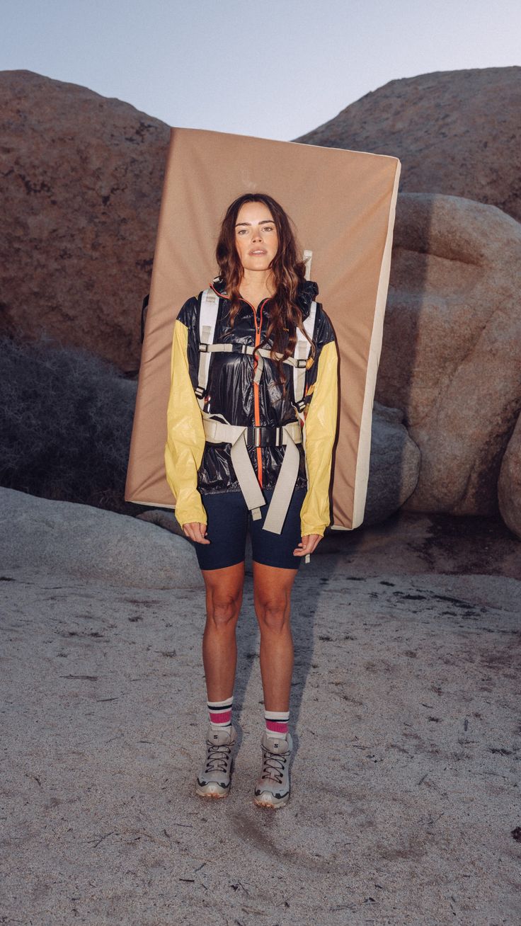 a woman standing in front of a rock formation