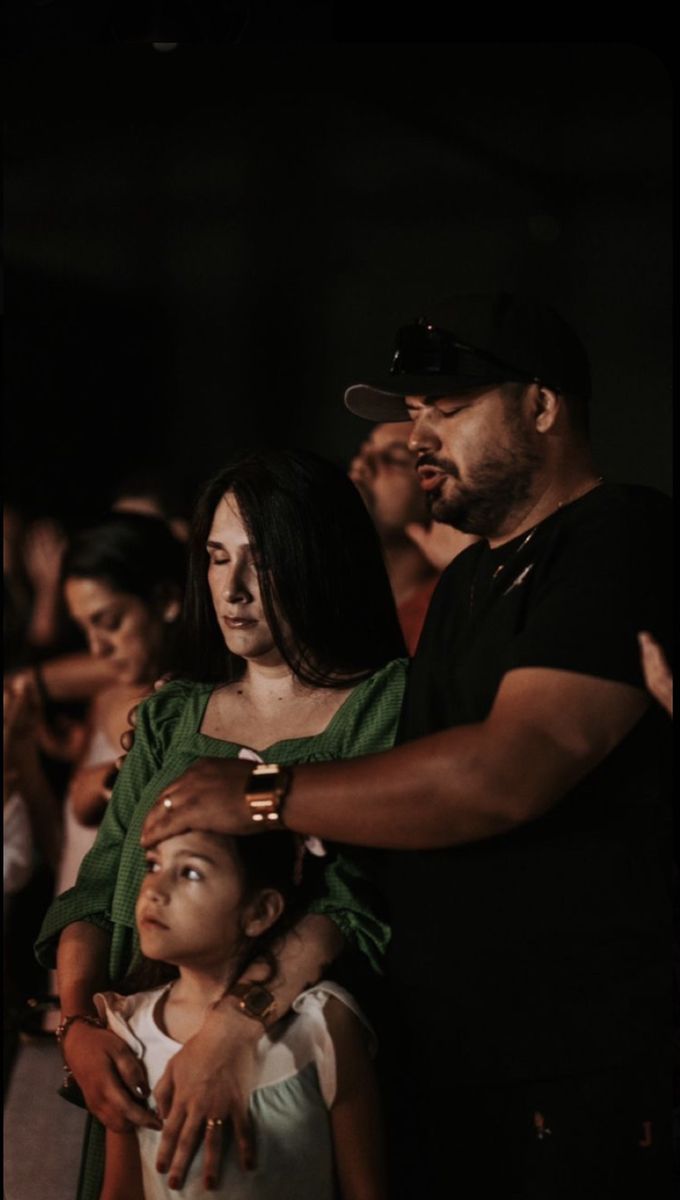 a group of people standing next to each other in front of a man holding a child