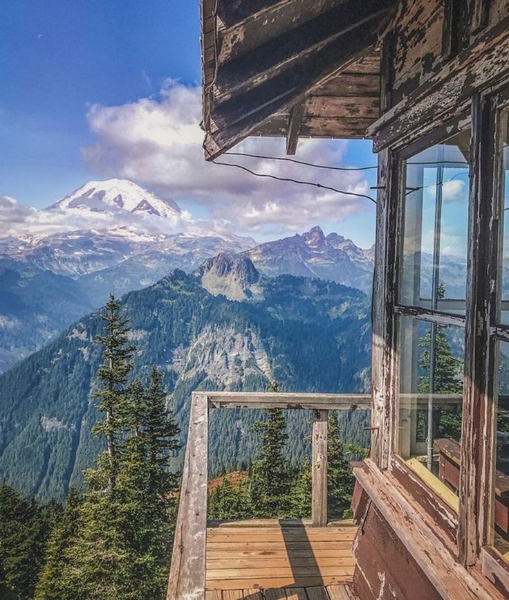 a balcony with a view of the mountains and snow - capped mountain range in the distance