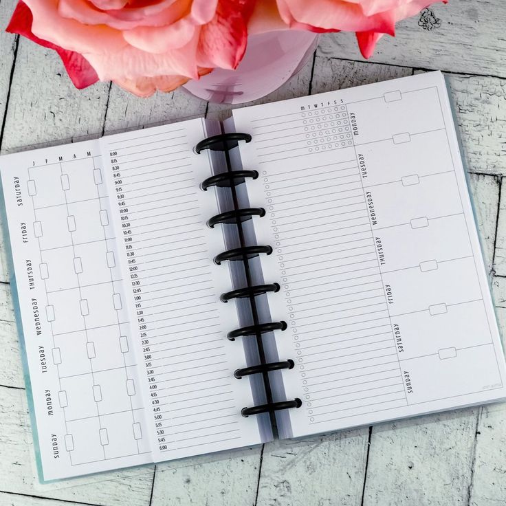 an open planner with pink flowers on top