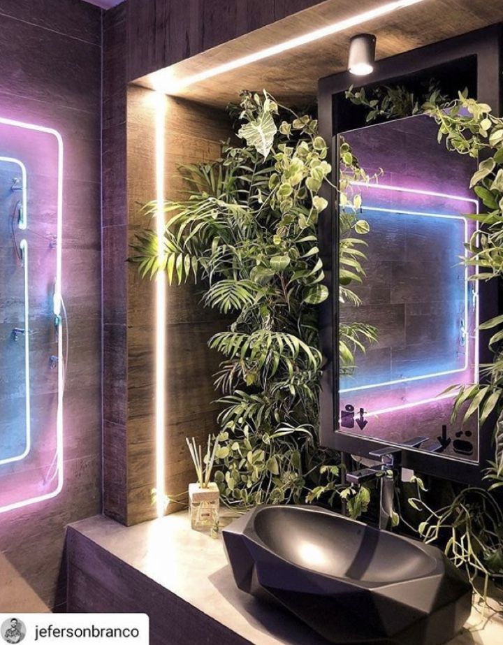 a bathroom with plants on the wall and a sink in front of a large mirror