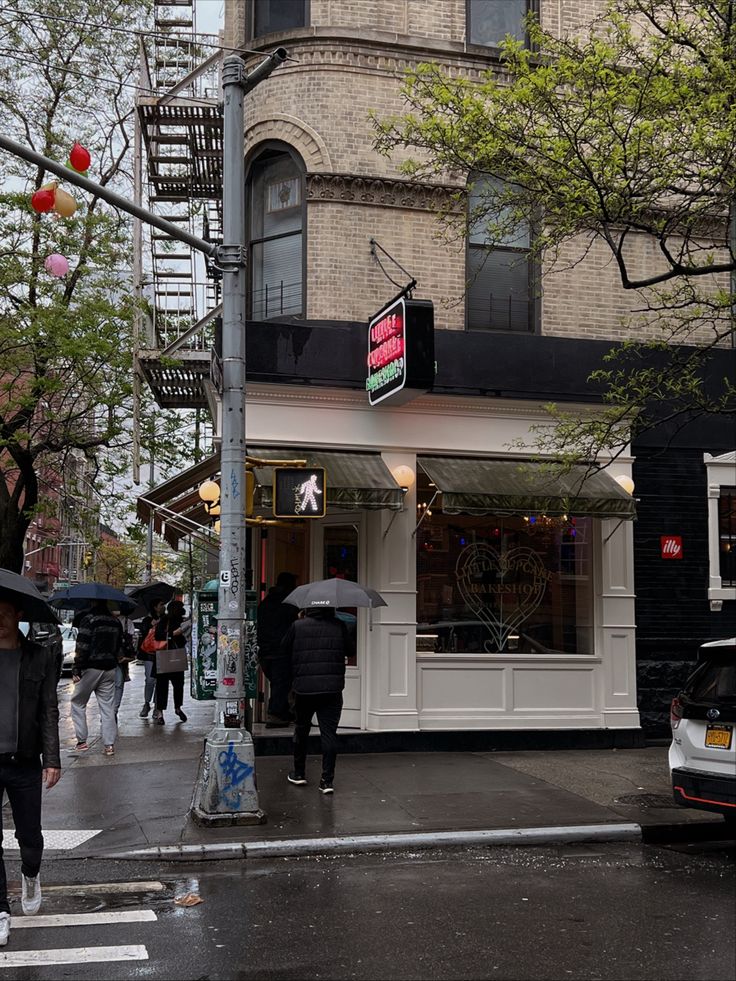 people are walking down the street with umbrellas