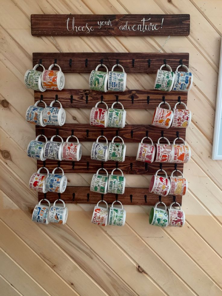 there is a coffee cup display on the wall with mugs hanging from it's hooks