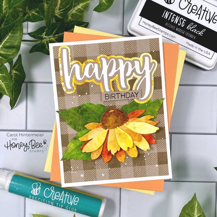 a card that says happy birthday with a sunflower on it next to some leaves