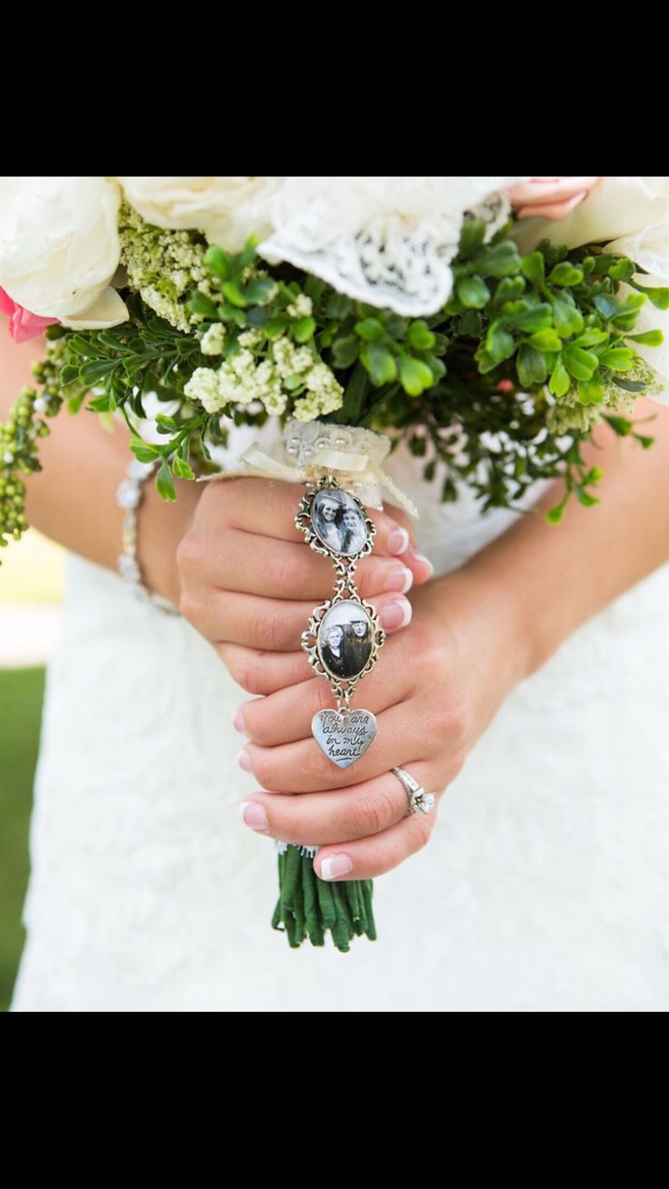 a woman in a wedding dress holding a bouquet of flowers and rings on her hands