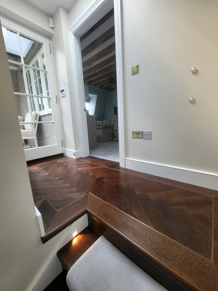 an empty room with wooden floors and white walls