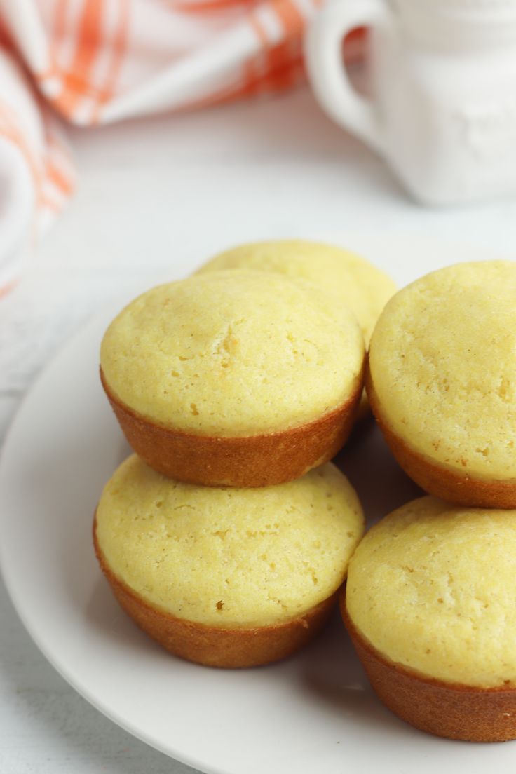 a white plate topped with four yellow cupcakes