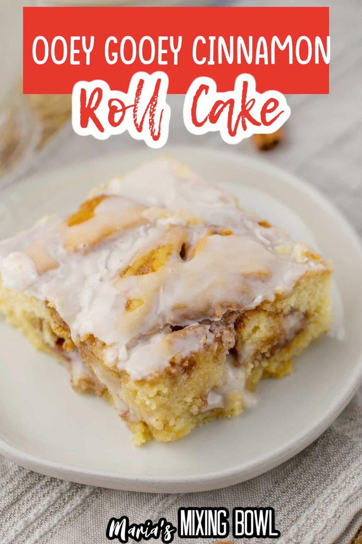 a close up of a piece of cake on a plate with icing and cinnamon rolls