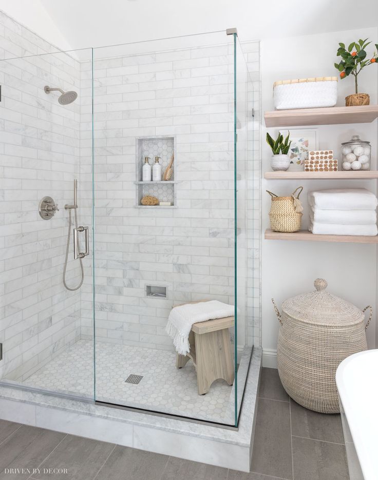 a bathroom with a walk in shower next to a bath tub and toiletries on shelves