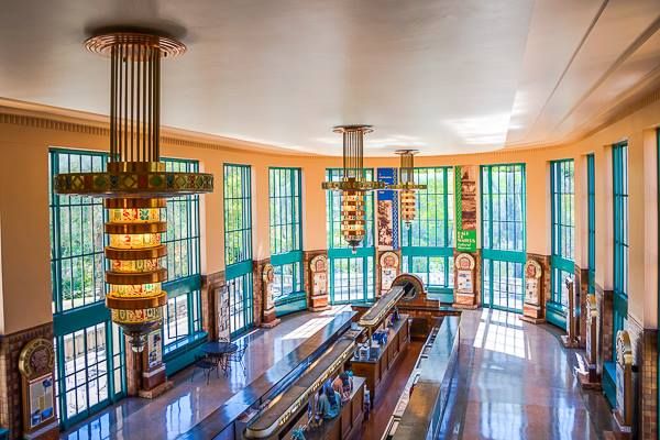 the inside of a large building with many windows and chandelier hanging from it's ceiling