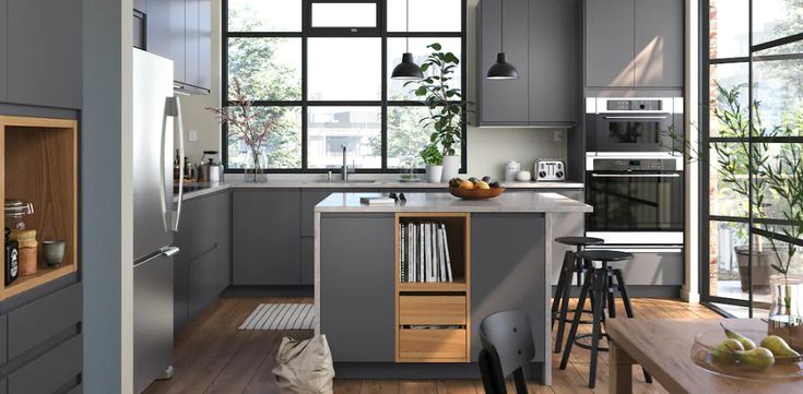 a kitchen with gray cabinets and wooden floors