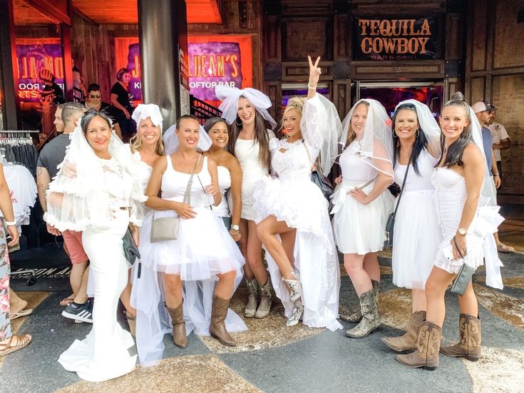 a group of women dressed in white posing for a photo