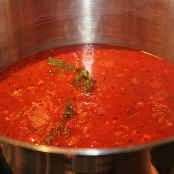 a pot filled with red soup sitting on top of a stove