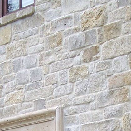 a cat sitting on top of a window sill in front of a brick building