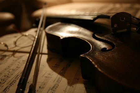 an old violin laying on top of sheet music