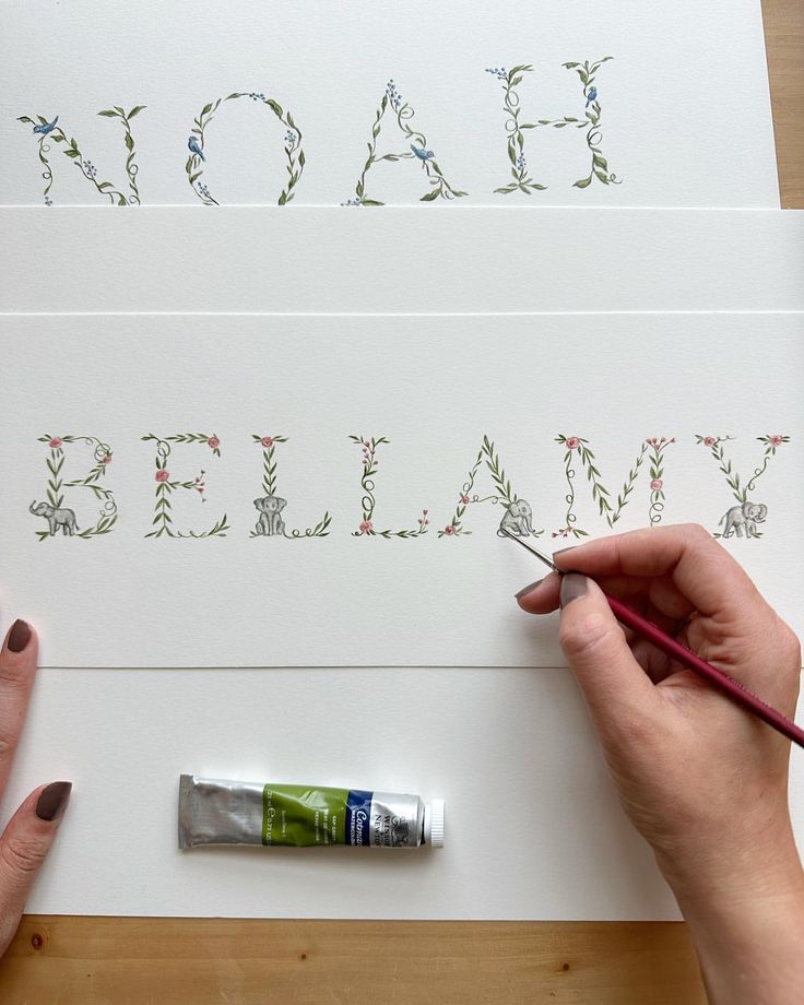 someone is painting the letters on paper with paintbrushes and watercolor pencils