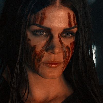 a woman with makeup and blood on her face