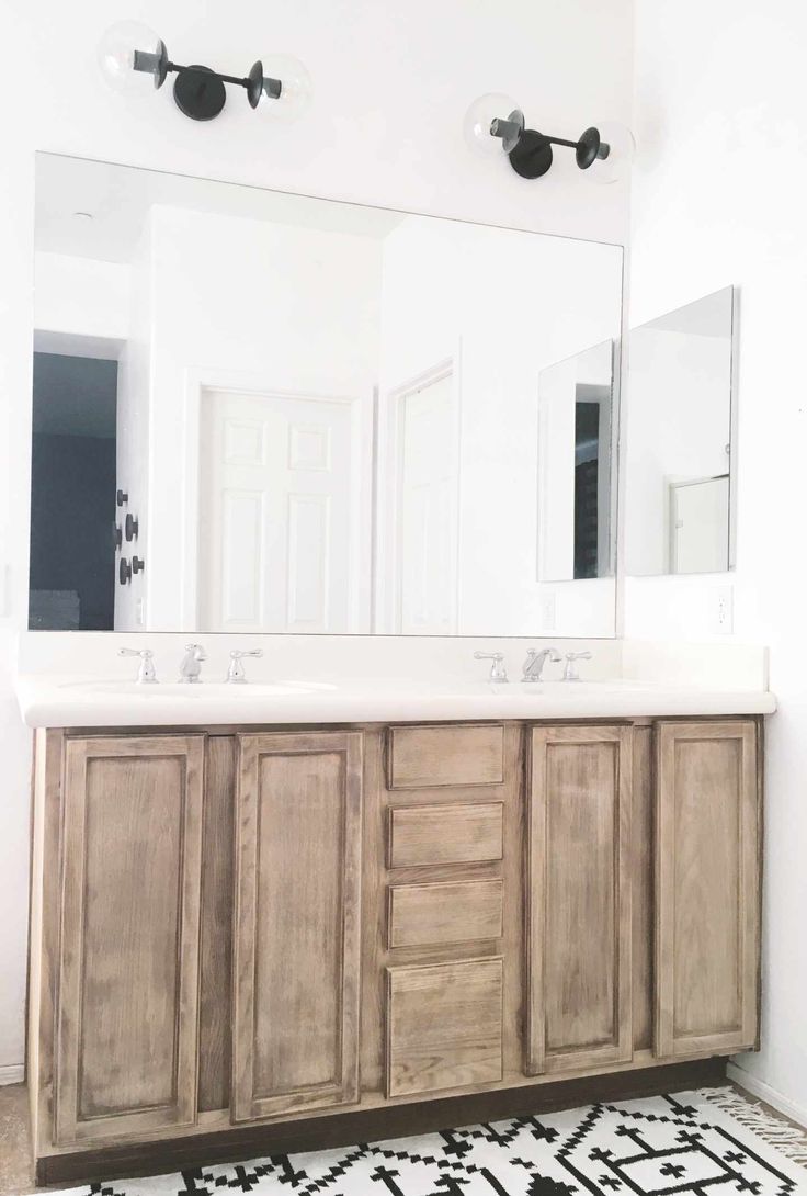 a bathroom vanity with two sinks and mirrors