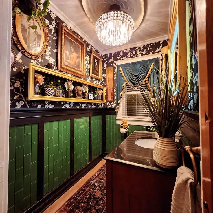 an ornate bathroom with green tile and pictures on the wall, along with potted plants