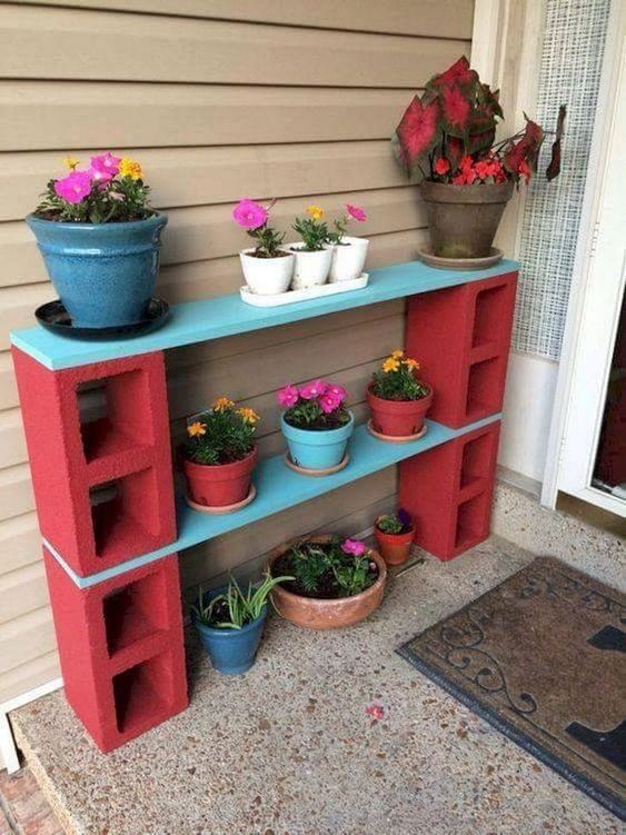 an outdoor shelf with potted plants on it and two flower pots sitting on top