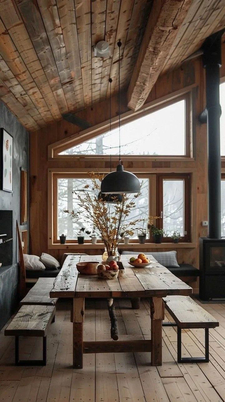 a wooden table sitting under a window next to a fire place