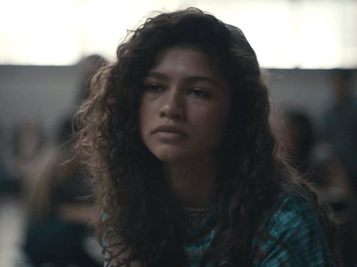 a close up of a person with long hair and an unkempt look on her face