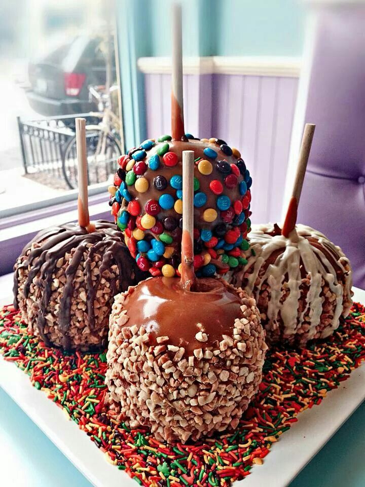 three chocolate covered donuts on a plate with sprinkles and candy sticks