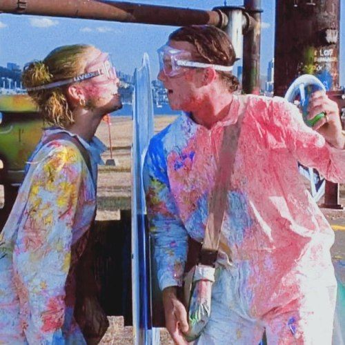 two people covered in paint standing next to each other