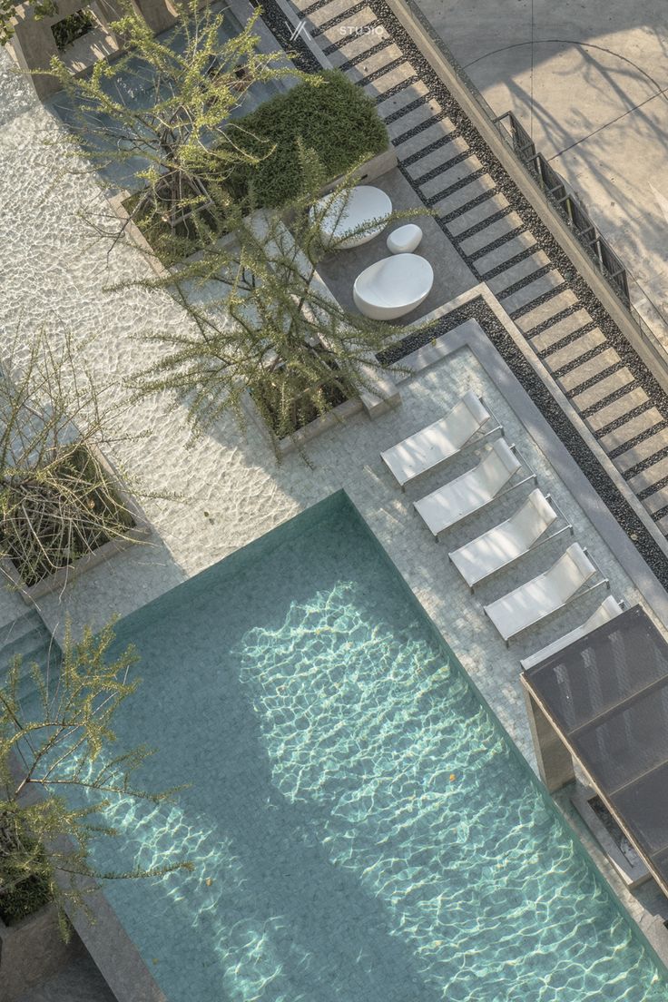 an aerial view of a swimming pool with lounge chairs