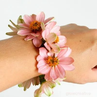 a woman's arm with pink flowers on it and green stems in the middle