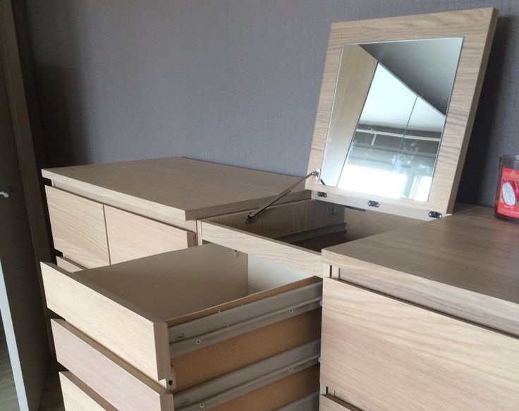 a dresser with drawers and a mirror on it